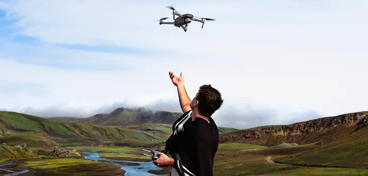 Man in a valley in front of a river letting Stealth Bird 4K Drone loose